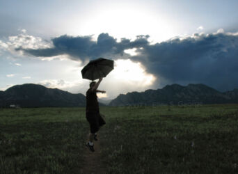 Digital photo of photographer's husband Greg celebrating the clearing of a storm with an umbrella still in his hand, suspended in mid-jump © 2007 L. Eilee S. George