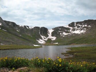 Digital photograph of Summit Lake on Mt. Evans, with day lilies blooming in the foreground and the snow-kissed crescent-shaped crater/mountain formation in the background © 2009 L. Eilee S. George