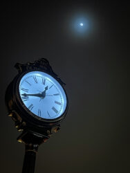 Clock in Old Town Arvada with moon © 2022 L. Eilee S. George