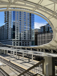 Partial view of pavilion over platform at Union station framing other Denver buildings © 2022 L. Eilee S. George